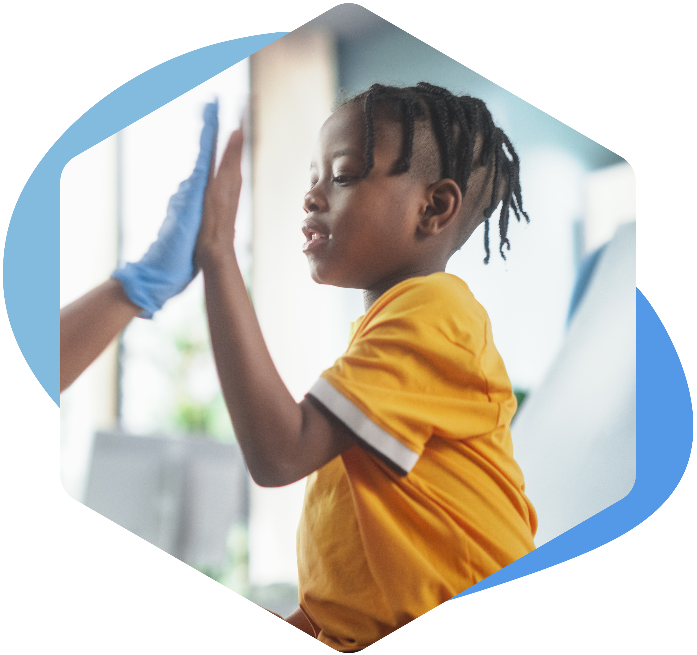 child high-fiving a medical professional wearing a blue plastic glove.