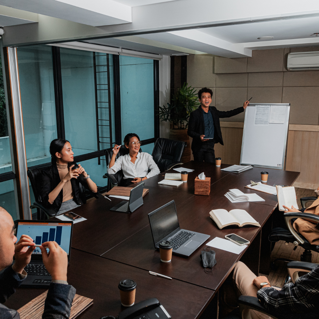 A group discussion/presentation around a table.